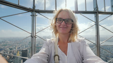 Portrait-Of-A-Happy-Woman-Shooting-Herself-On-Video-Against-The-Background-Of-The-City-Of-New-York