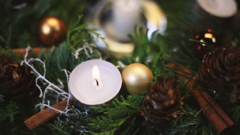 the woman lights a candle on an advent wreath, the background slightly blurred