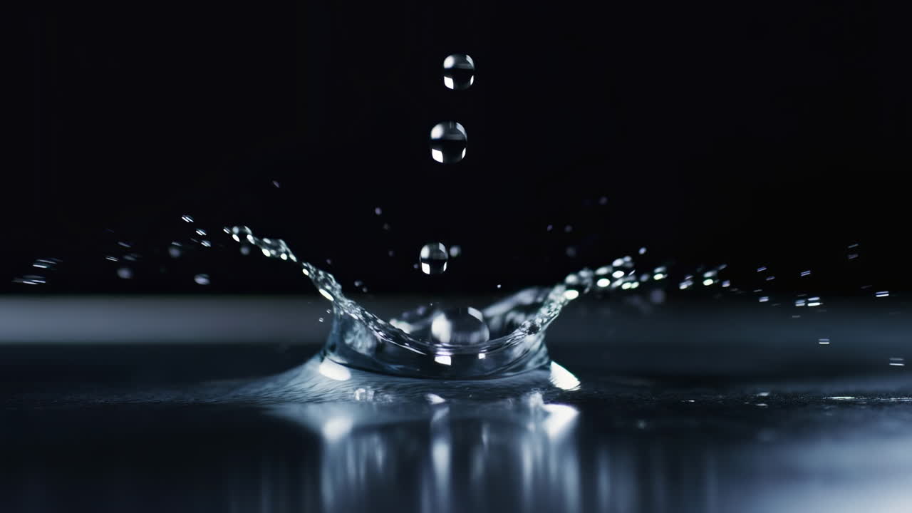 Close Up Water Droplets Striking Black Surface, Dramatic Cinematic Slow Motion Capture Revealing Crystal Clear