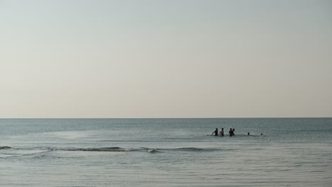 Silueta-De-Un-Grupo-De-Hombres-Jóvenes-Jugando-Voleibol-De-Agua-En-El-Mar