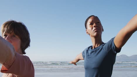 Multiethnische-Gruppe-Von-Frauen,-Die-Yoga-Position-Am-Strand-Und-Im-Hintergrund-Des-Blauen-Himmels-Machen