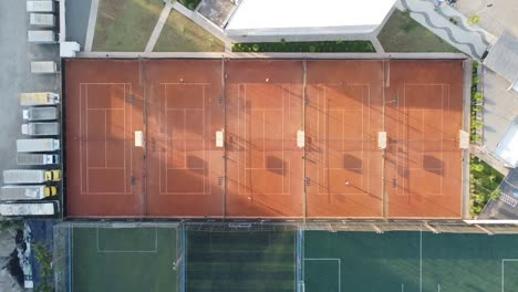 beautiful-clay-tennis-courts-at-sunrise-filmed-with-drone,-camera-down-90-degrees