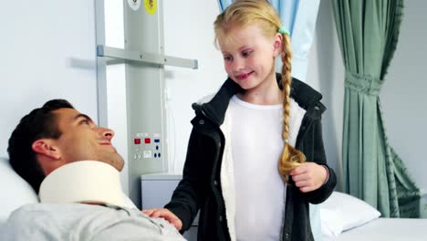 Man-lying-in-medical-bed-and-girl-standing-near-by