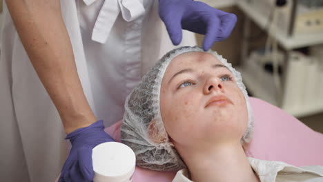 teenage girl getting facial treatment