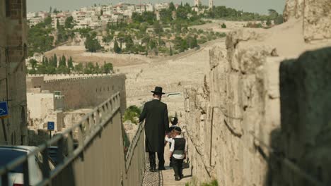 religious orthodox haredi jew walks in the holy city of jerusalem with family of israel