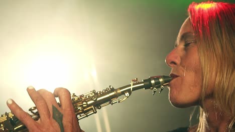 disparo en cámara lenta de una clarinetista rubia tocando una canción y poniendo su actuación durante un gran concierto con expresiones faciales y gestos conmovedores