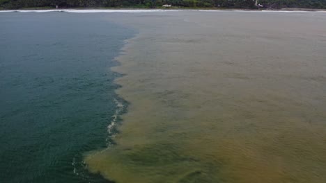 Aéreo:-Mezcla-De-Agua-Dulce-Que-Choca-Con-El-Agua-Salada-Del-Océano,-Estuario-Del-Mar-Del-Río