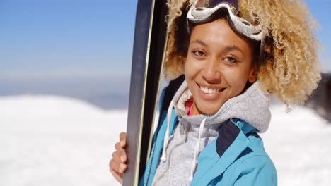 thoughtful young woman standing holding her skis