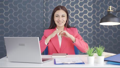 young business woman making a trust sign at the camera.