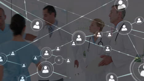 animation of network of connections with icons over diverse doctors discussing work in hospital