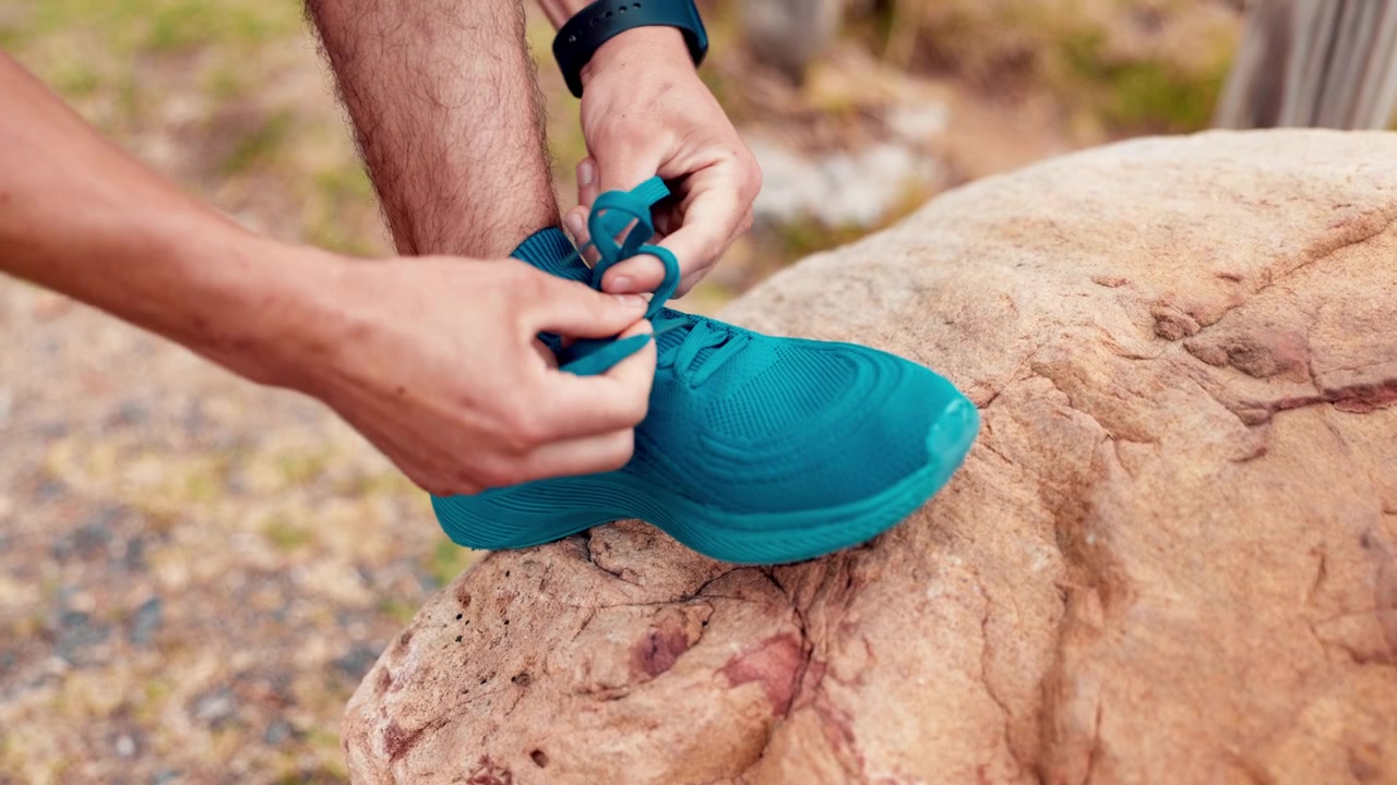 Corridore che Allaccia le Scarpe su una Grande Roccia all'Aperto