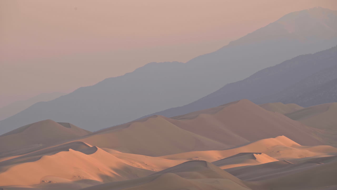 Paesaggio con teleobiettivo di imponenti dune di sabbia con catena montuosa sullo sfondo