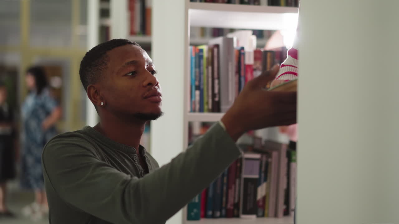 Black guy takes books from assistant in library. African American man gathers literature with librarian assistance in college storage. Constant reader