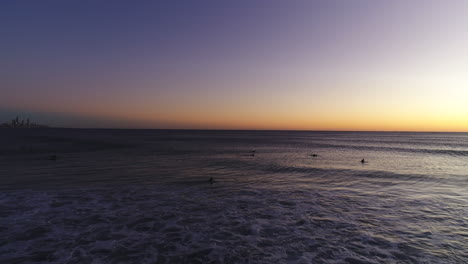 Drone-Aéreo-Volando-Hacia-Un-Grupo-De-Surfistas-Esperando-La-Ola-Perfecta-Durante-Un-Hermoso-Amanecer-En-La-Muy-Popular-Burleigh-Heads-Gold-Coast-Qld-Australia