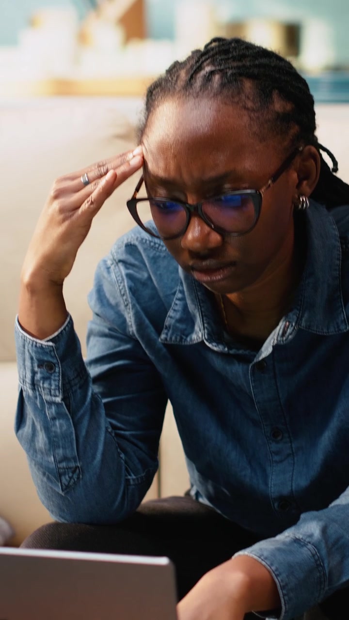 Vertical Video Uncertain young woman frowning about ambiguous tasks at home