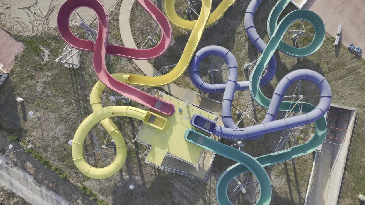 toma aérea de arriba hacia abajo de toboganes coloridos del parque acuático cerrado en bucarest