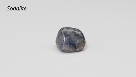 piedra de sodalita que gira sobre una superficie blanca