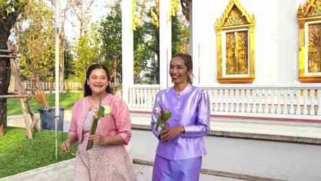 two women in thai traditional dress at a temple