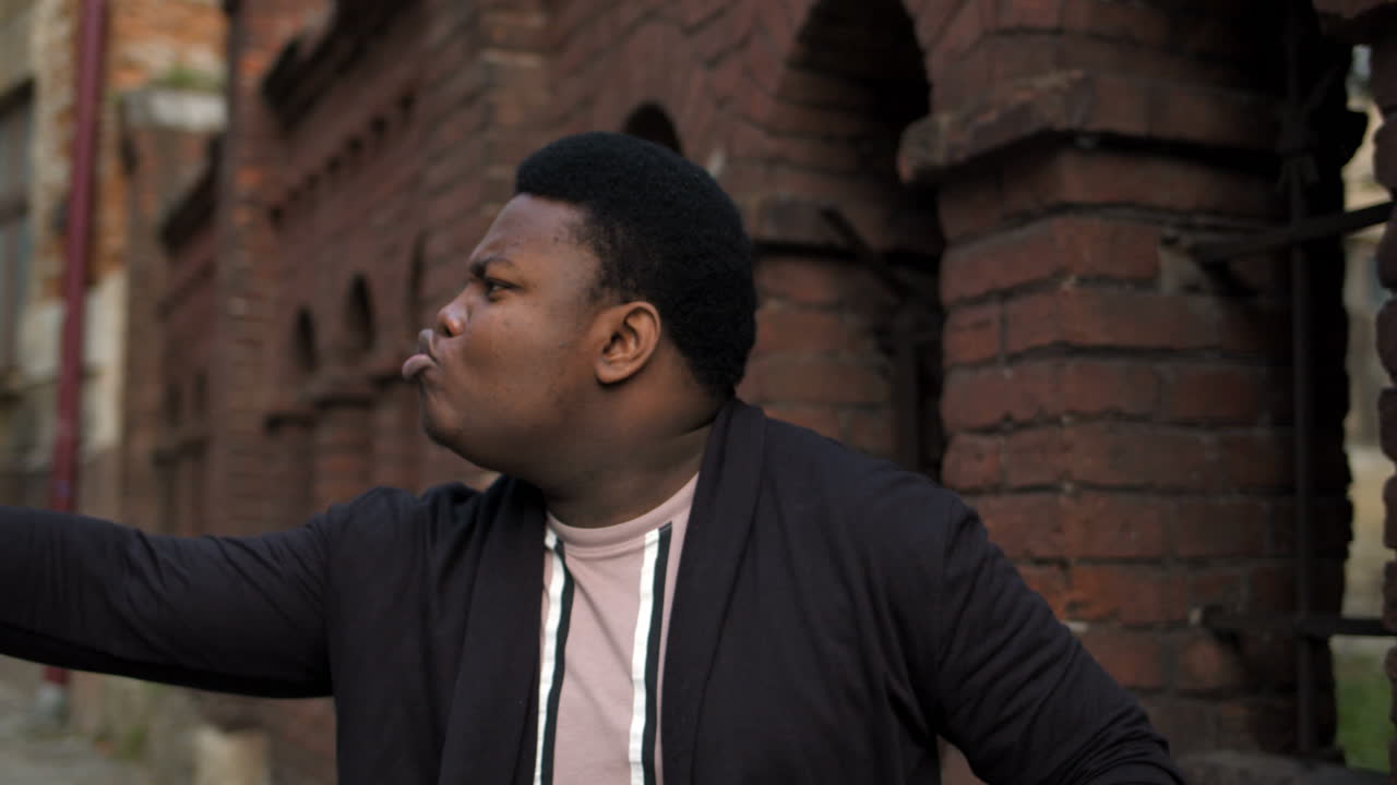 Man outdoors against a brick wall