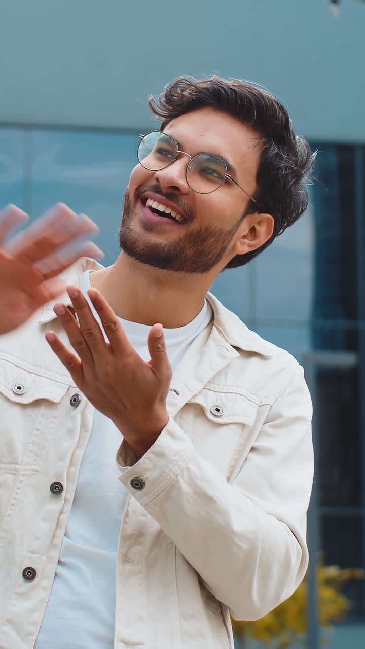 Cheerful rich indian man showing wasting throwing money win lottery share celebrate in city street