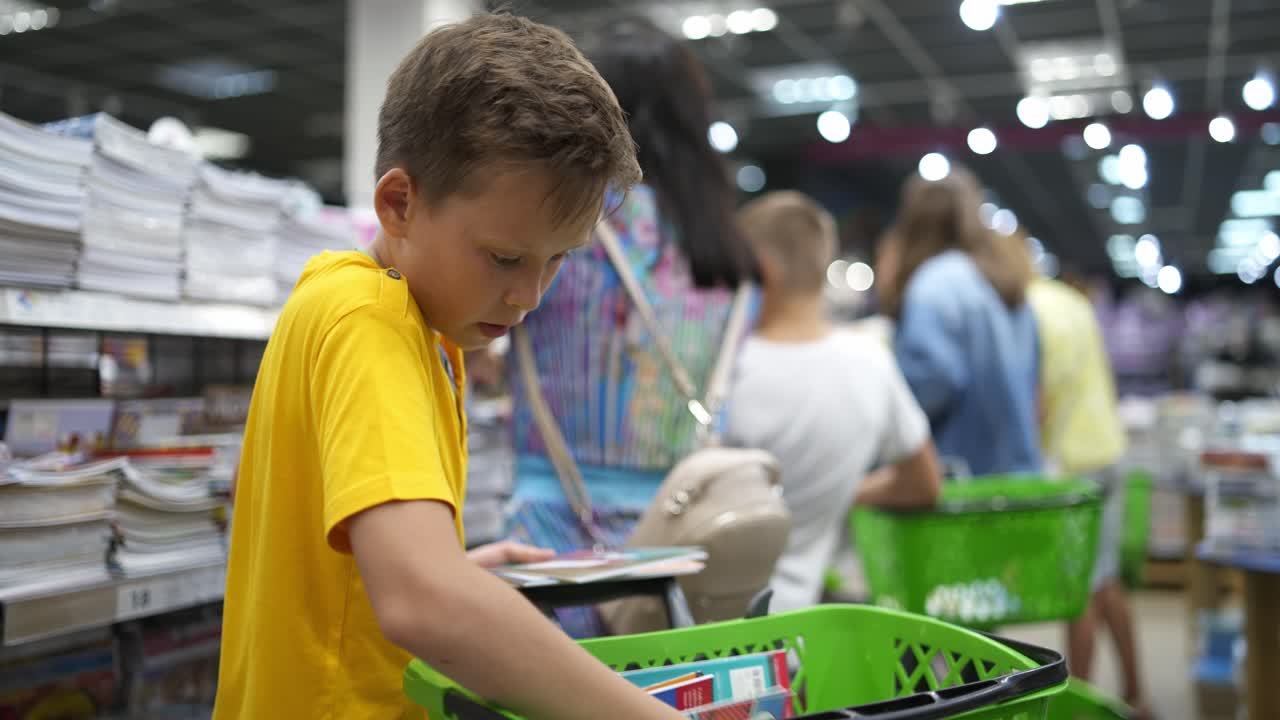 Young boy in shop. Boy choosing notebook in the store