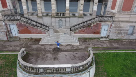 young dancer doing a front flip over steps aerial drone view