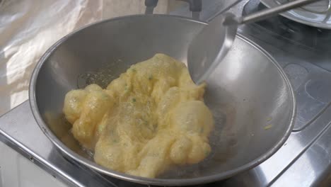 chef cooking fluffy omelette in the kitchen.  pouring mixed egg in to hot oil. 60fps