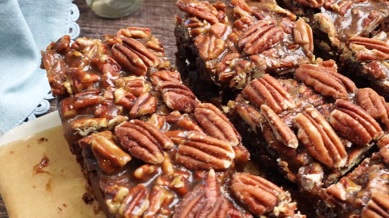 Baking delicious caramel pecan brownies. Panning across the baking pan with caramel pecan brownies. Freshly baked gooey chocolate brownies with sweet caramel and nutty pecans.
