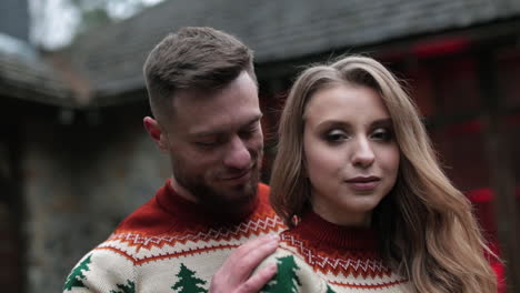 affectionate couple in the same sweaters standing outdoors. happy couple having romantic date at the nature background.