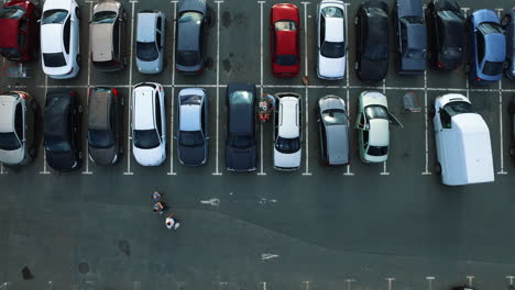 Drone-footage-man-opening-car-door.-Copter-flying-above-supermarket-parking