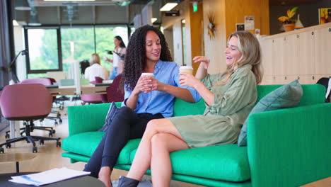 Mujeres-Empresarias-Con-Café-Teniendo-Una-Reunión-Informal-En-La-Zona-De-Descanso-De-La-Oficina-Moderna