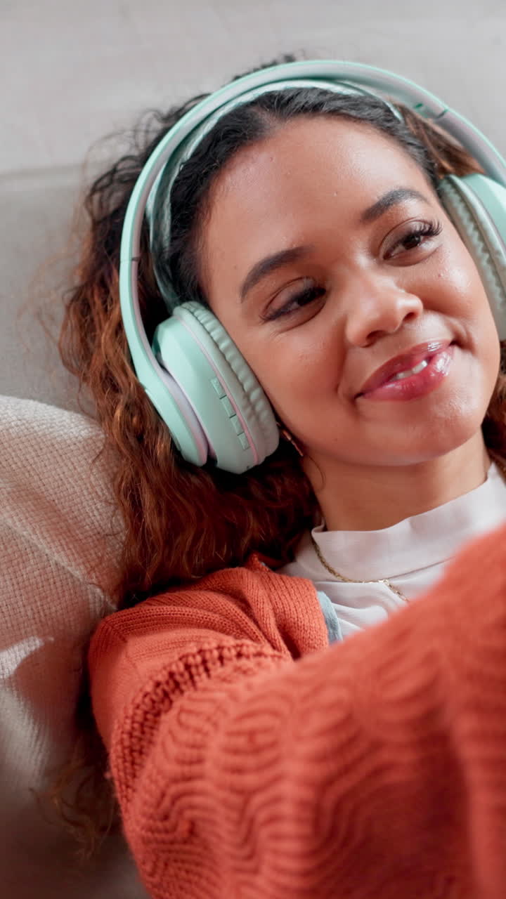 Giovane donna felice che ascolta musica con le cuffie e sorride