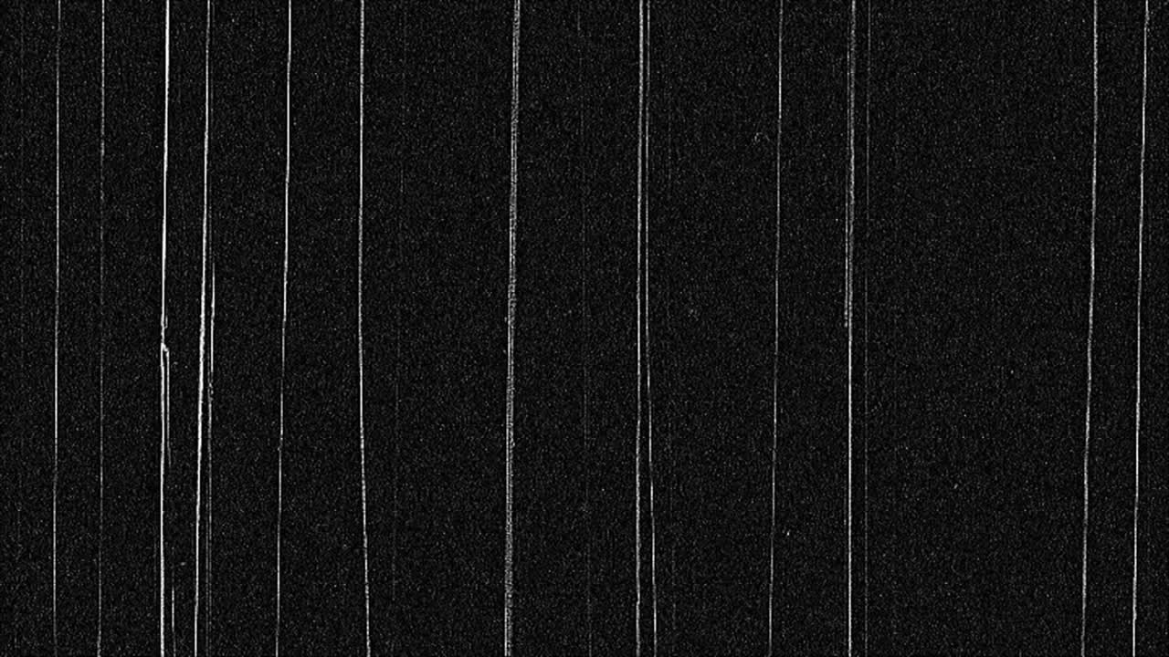 Authentic vintage film effect with heavy vertical scratches, dust, and noise on a black background. Use as an overlay for a retro or damaged look