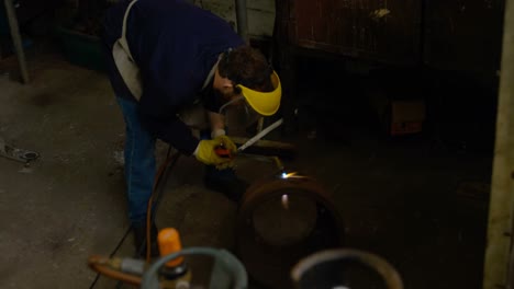 metalsmith using welding torch in workshop 4k