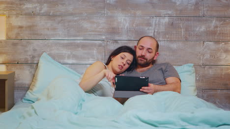 caucasian couple in pajamas lying in bed