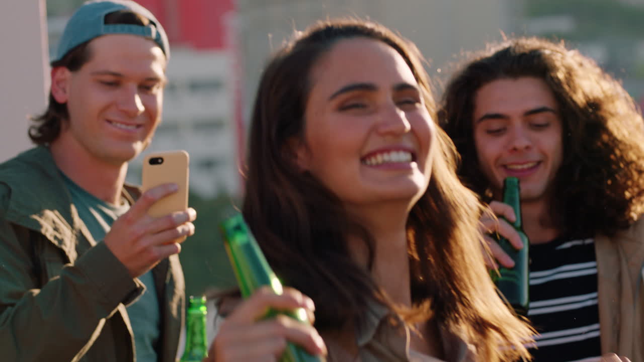 grupo de amigos diversos saliendo a bailar juntos mujer caucásica disfrutando de una fiesta en la azotea música de baile al atardecer bebiendo alcohol divirtiéndose el fin de semana reuniéndose
