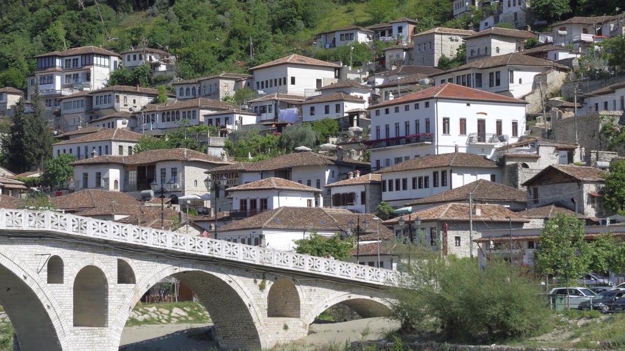 Berat, Albania: ponte ad arco in pietra sotto il quartiere Mangalem di case ottomane bianche sul fianco della collina.