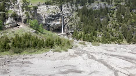 fast aerial towards a waterfall cutting its wa through a massive rock formation