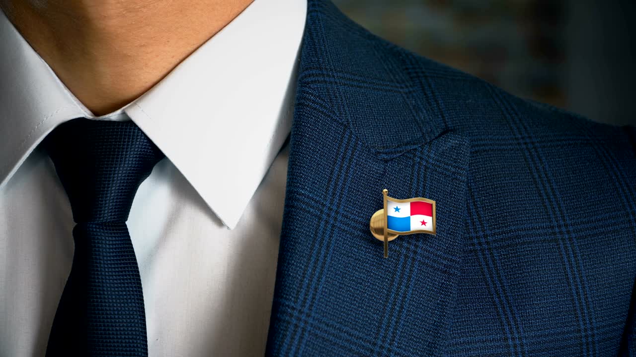 hombre de negocios caminando hacia la cámara con el pin de la bandera del país - panama
