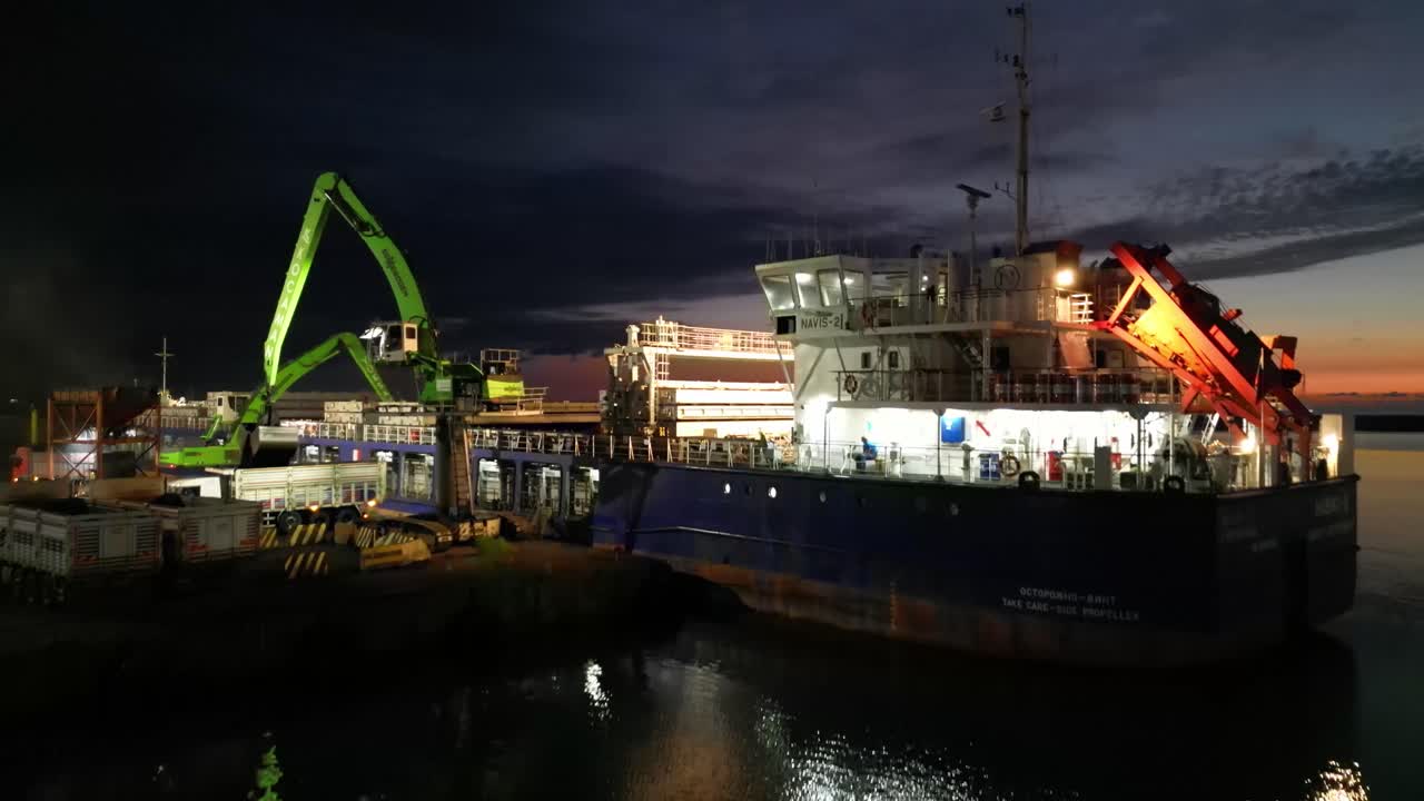 un video que captura el encantador reflejo de las luces danzantes de los barcos que esperan en el puerto en la superficie del mar