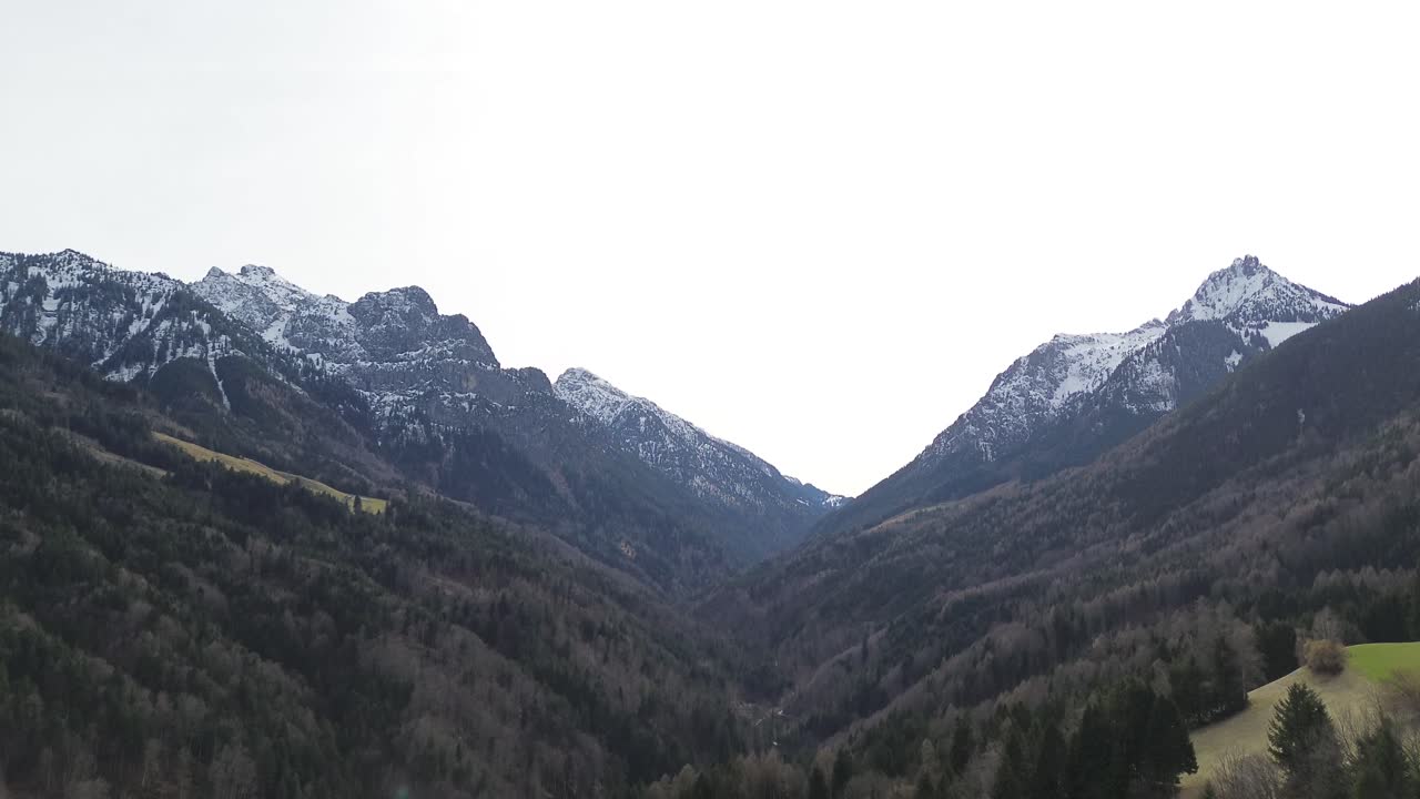 paisaje montañoso en invierno con bosque de árboles cubierto de nieve en el fondo, vuelo aéreo de drones sobre árboles, video de 4k 30 fps