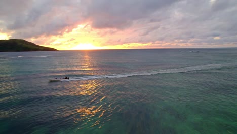 Gente-Saludando-Desde-Un-Bote-Tierno-Navegando-Durante-Una-Puesta-De-Sol-Dorada,-Yasawa,-Fiji