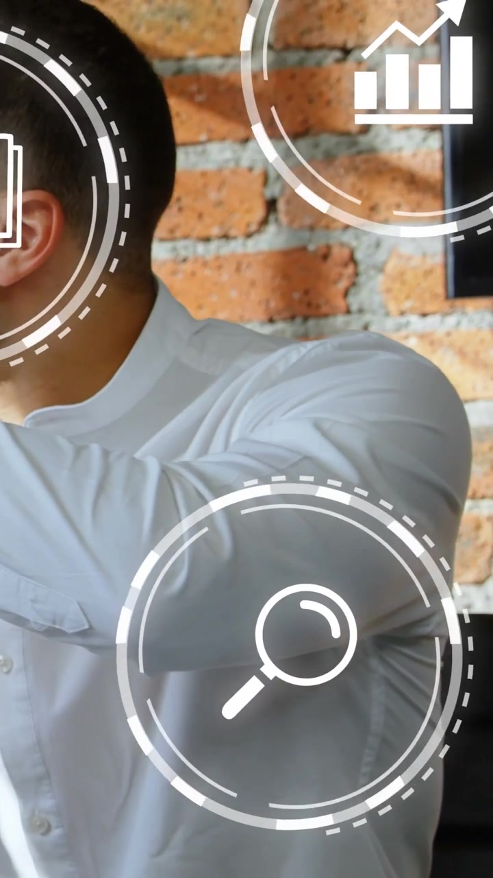 Video verticale: Icone HUD che appaiono, uomo che gira la testa e muove il braccio mostrando dati tecnologici.