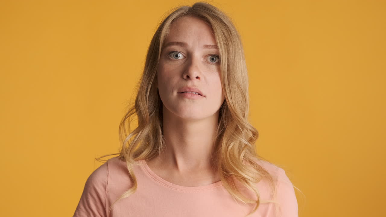 una mujer caucásica mirando sorprendida a la cámara.