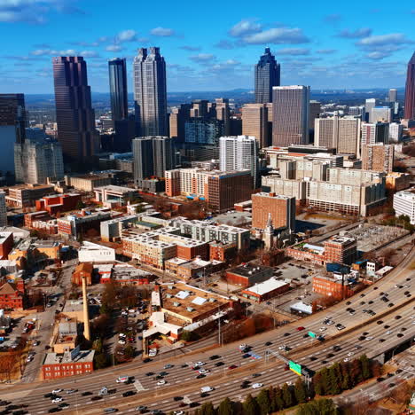 vast scenery of atlanta downtown with few skyscrapers in the middle. lots of cars drive by the wide-lane roads. top view.
