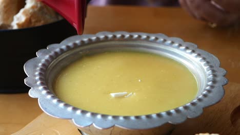 woman pouring butter into a bowl of turkish soup