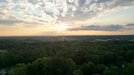 el sol se pone sobre un paisaje exuberante y boscoso, proyectando un resplandor dorado a través del cielo