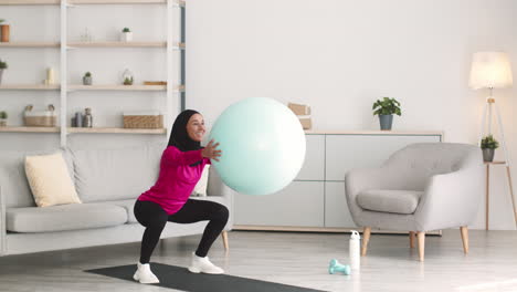 mujer haciendo ejercicio con una pelota de yoga en casa