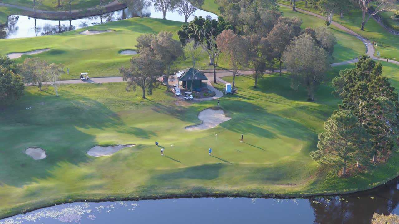 Aerial footage captures golfers on a lush green course at sunset, highlighting serene landscapes and vibrant colors