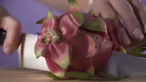 dragon fruit white pulp cut with sharp knife over a kitchen table board close up in slow motion healthy organic tropical fruit food diet lifestyle